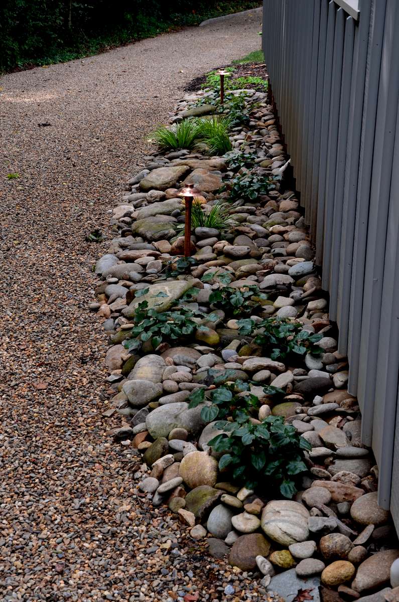 A freestanding garage located at the back entrance of the property is outfitted with river rock and perennials to help combat erosion and add character to an otherwise forgotten space.