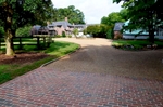 Through a complete upgrade of the property's driveway including the area that begins with the brick pad at the street, we installed a cobblestone border that shapes and defines. In addition, Virginia river rock extends throughout the roads within the property.