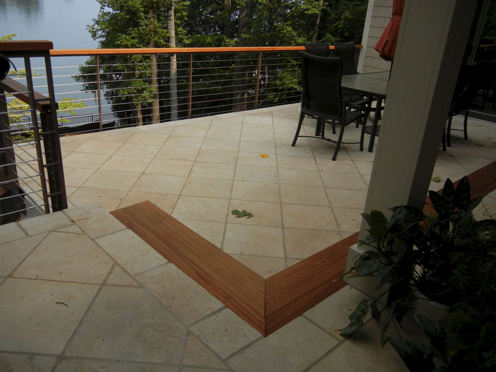 The project includes an urban outdoor living space that includes a sunken Travertine patio with cable rail. The railing helps open up the view and is asethetically appealing.