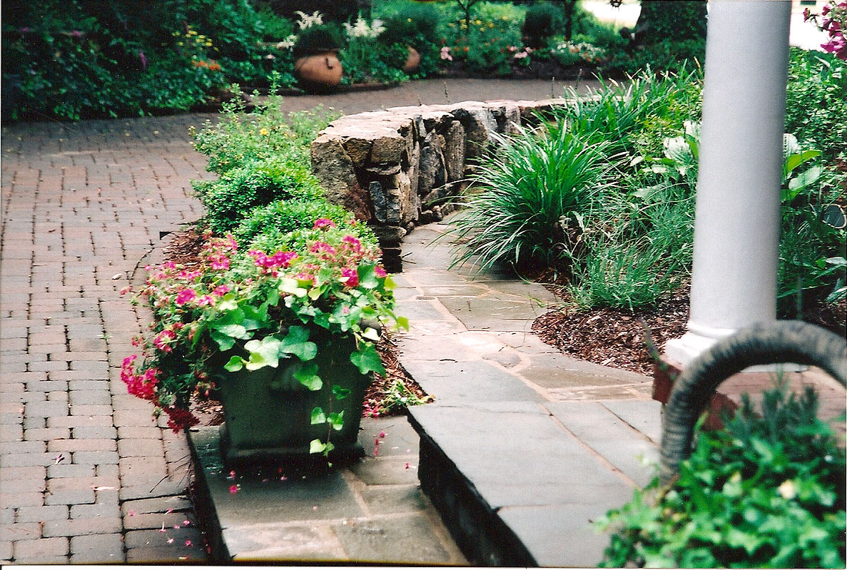 Elegant stonework and English-inspired perennials sweep you into the feeling of being in a formal English garden, right  in NC!