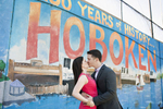 engaged couple in front of Hoboken mural during their engagement session. Hoboken wedding photographers
