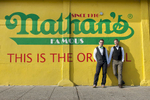grooms in front of Nathan's Hot Dog in Coney Island. NYC wedding photographers