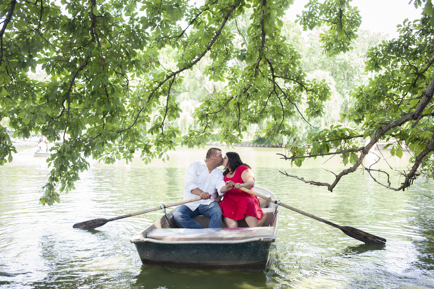 engaged couple kissing in a row boat at the Boat House in Central Park. NYC wedding photographers