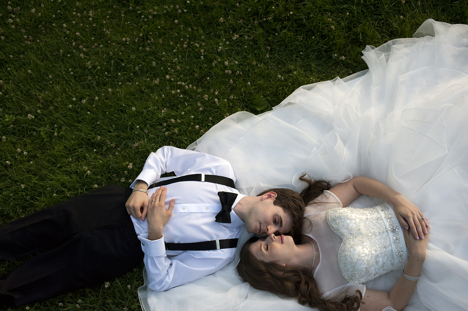 bride and groom laying in the grass at Celebrate at Snug Harbor