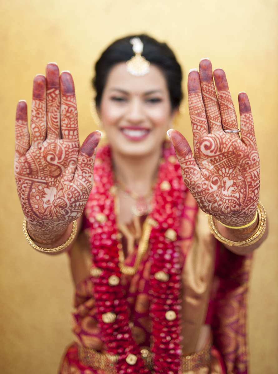 indian bride showing off her henna on her hands.
