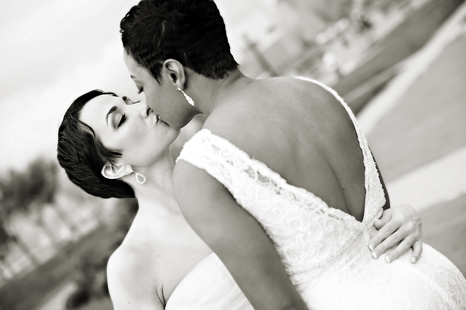 Portrait of brides kissing at Liberty State Park before their wedding at Liberty House. Lesbian wedding