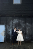 Portrait of bride and groom on roof of reBar in Brookln kissing against blue door. 