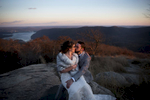 bride and groom kissing against the sunset sky at Bear Mountiain on their wedding day