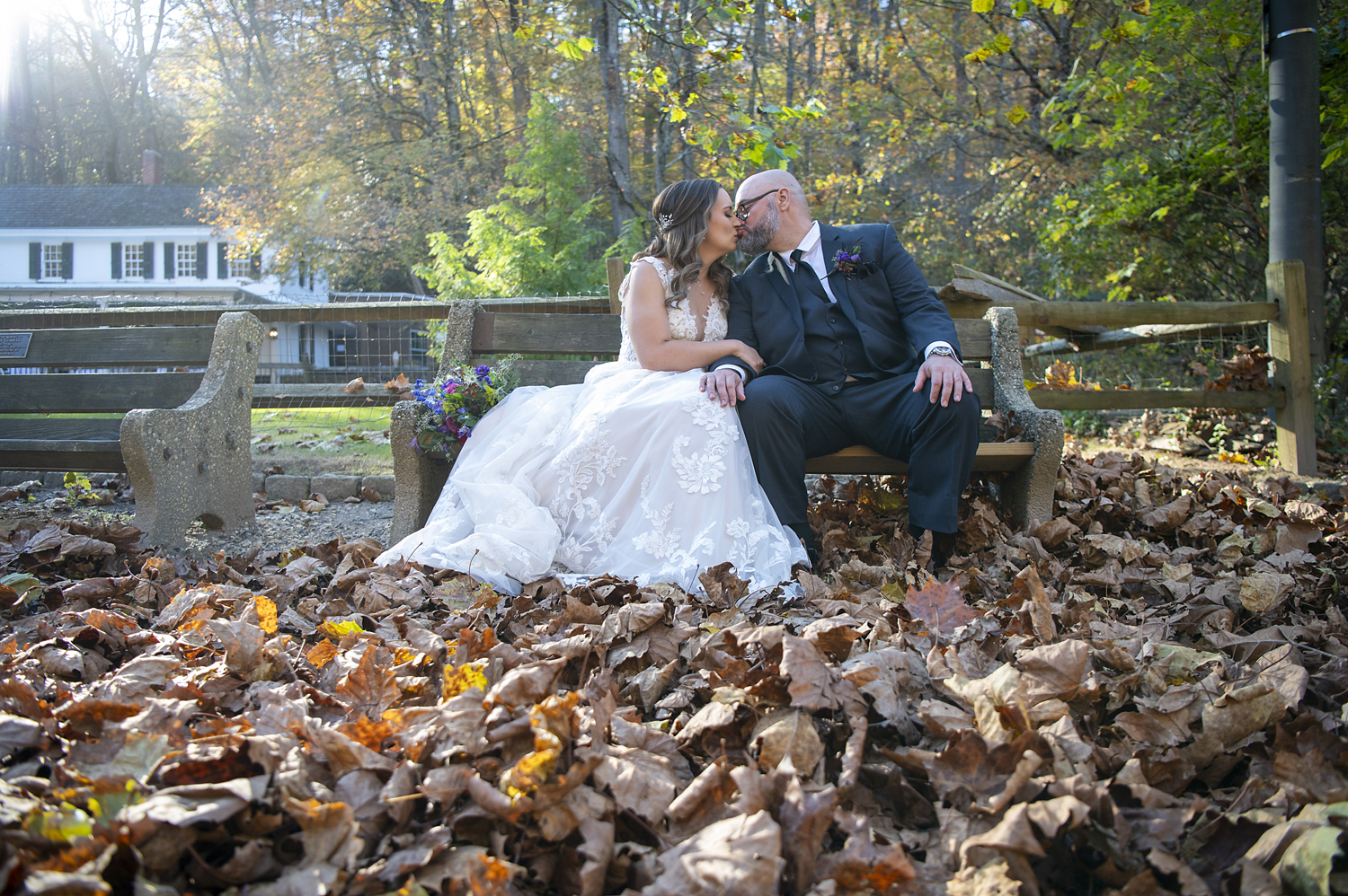 bride and groom kissing amongst the fall leaves
