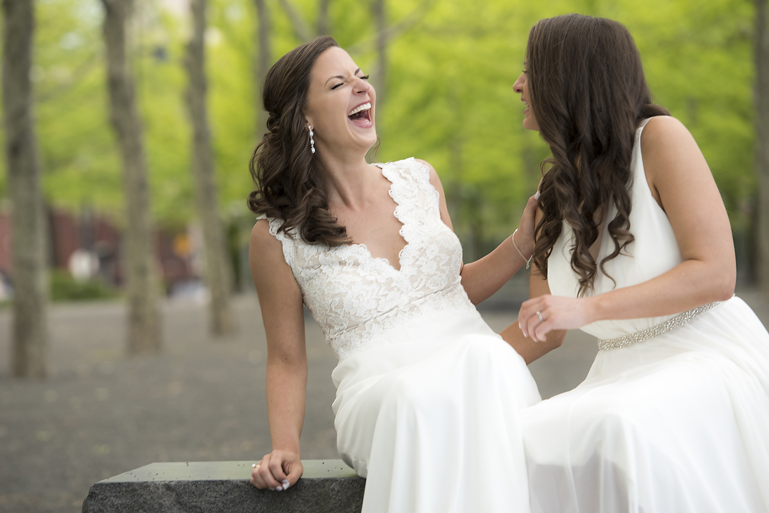 brides laugh during their portraits in Hoboken on their wedding day. LGBTQ Hoboken wedding photographer