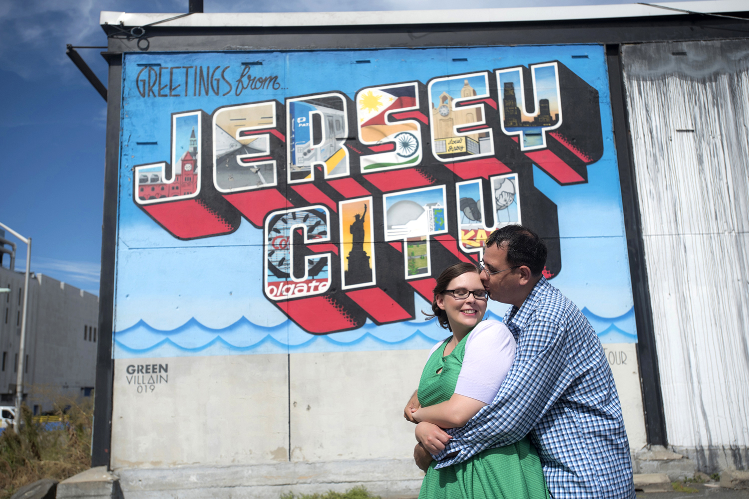 engaged couple in front of Jersey City mural during their engagement session. Jersey City wedding photographers