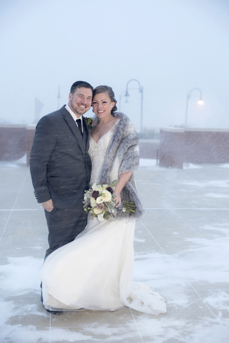 Blizzard wedding couple poses outside during winter wedding at the Hyatt Regency Jersey City. Jersey City Wedding Photographers
