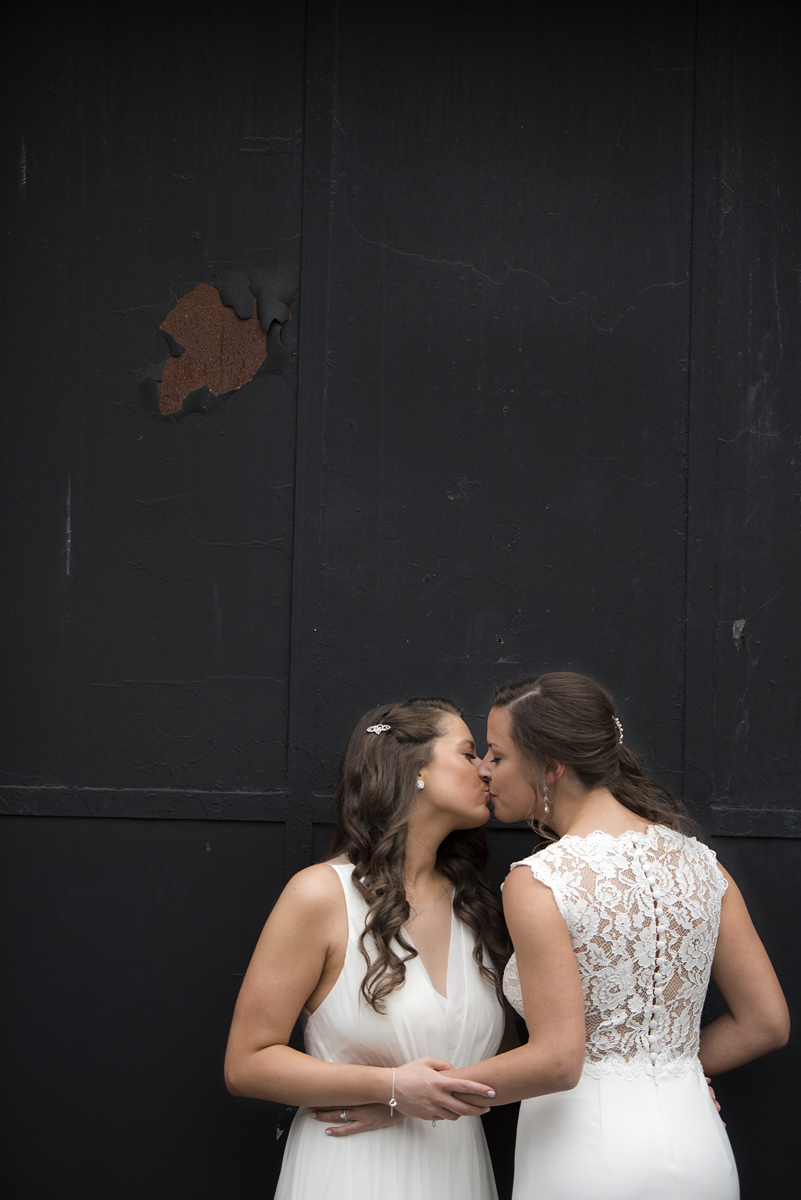brides kissing outside of Kolo Klub before their wedding celebration in Hoboken