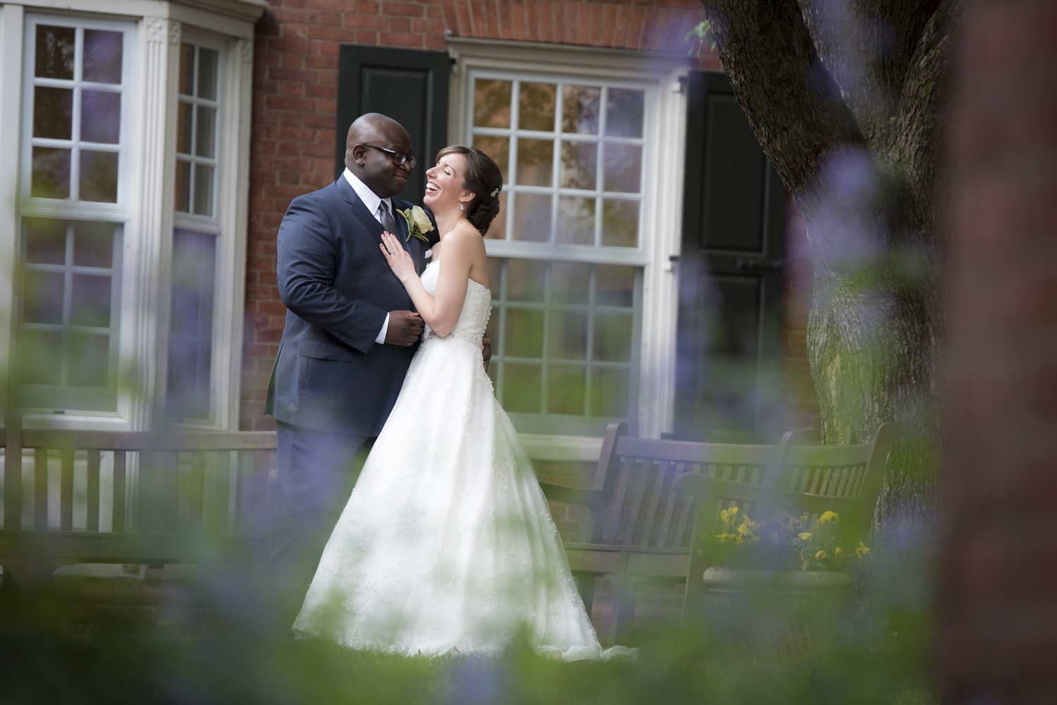 Biracial bride and groom laughing on their wedding day at Yale Divinity School in New Haven, CT.  
