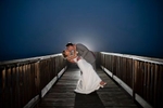 bride and groom kiss during blue hour on a dock