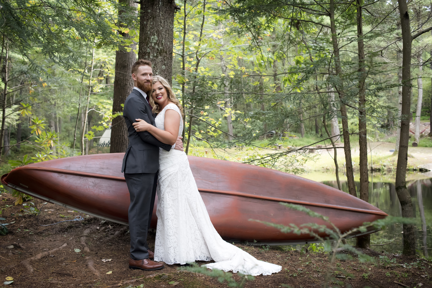 Bride and groom in front of canoe at Magnolia Streamside Resort