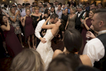 bride and groom kissing on the dance floor surrounded by family and friends at the end of their wedding at The Madison Hotel. 
