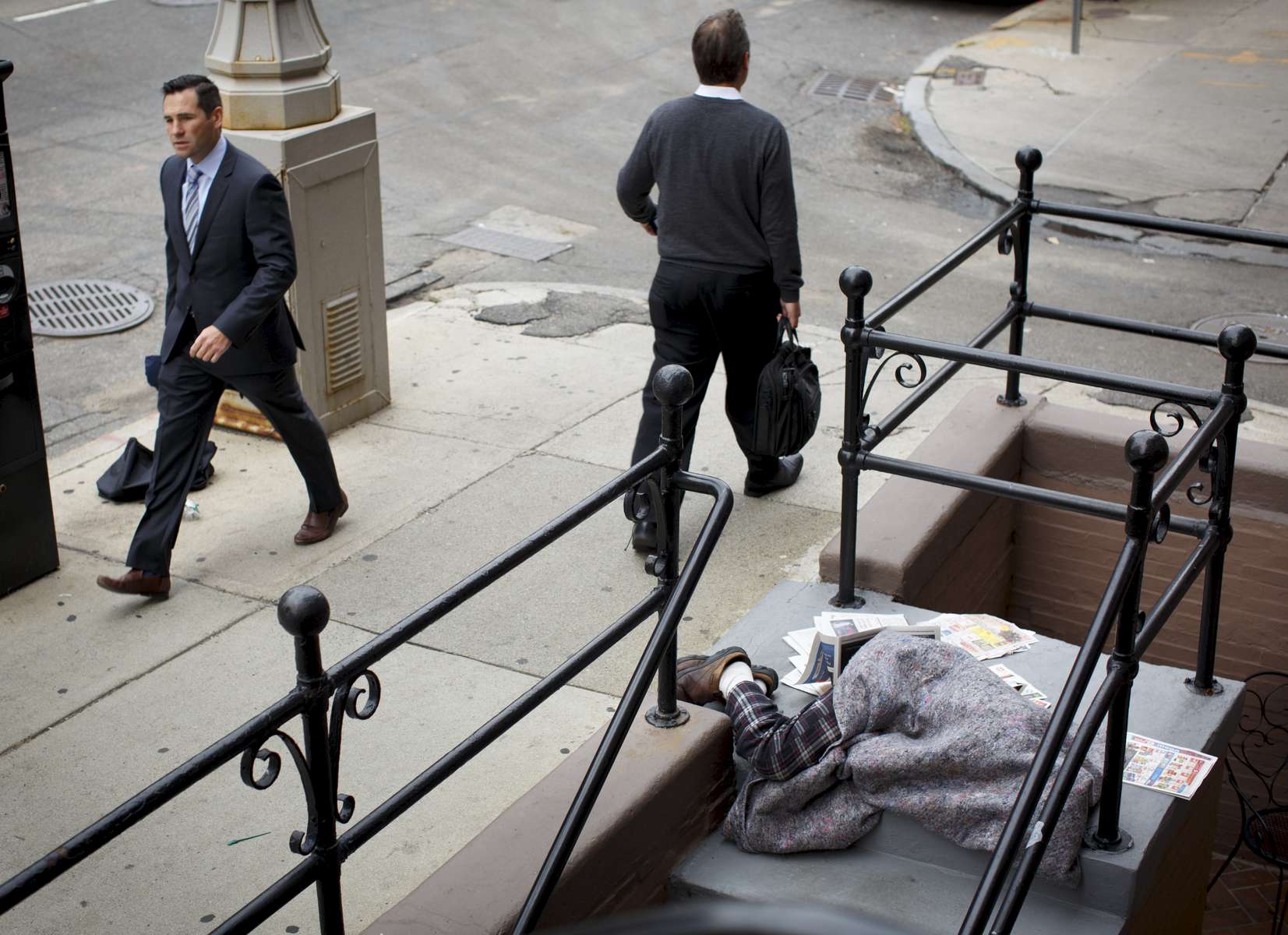 10/1/2015 - Boston, MA - Back Bay - Passersby rush past a homeless person sleeping on the steps of a Berkely Street business on Thursday morning, October 1, 2015. As concern about the city's chronic homeless population grows, business groups and other agencies are coordinating with the city to address the issue. Topic: 01homeless. Story by Katie Johnston/Globe Staff. Dina Rudick/Globe Staff.