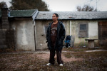 Rich Lone Elk, 24, a member of the North Side Tre Tre Gangsta' Crips, stands outside of his house, in Pine Ridge, South Dakota, on Wednesday, October 21, 2009.  Rich and the rest of his family live without running water or plumbing.