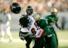 Cincinnati WR Marcus Barnett (85) gets his helmet knocked off by South Florida DB Mike Jenkins (4) during the first half of their game at Raymond James Stadium.