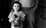 Portrait of Horacio Gomez Jr., 4, of Denver, holding a pigeon owned by his father Horacio Gomez and his uncle Fernando Gomez in a birdhouse in the backyard of Fernando's home in Denver, Colorado. They own 47 pigeons. Councilwoman Jeanne Faatz wants the city to reduce the number of pigeons residents may own. (Photo by Chris Schneider)