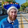 A Jewish male wearing a menorah on his hat, tie and sweater, and tie while crossing State Street in downtown Santa Barbara, California.