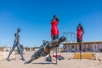 Contemporary 6 mannequin art installation painted, with restraints and bondage outside a building displayed on the ground in the settlement of Bombay Beach, California.