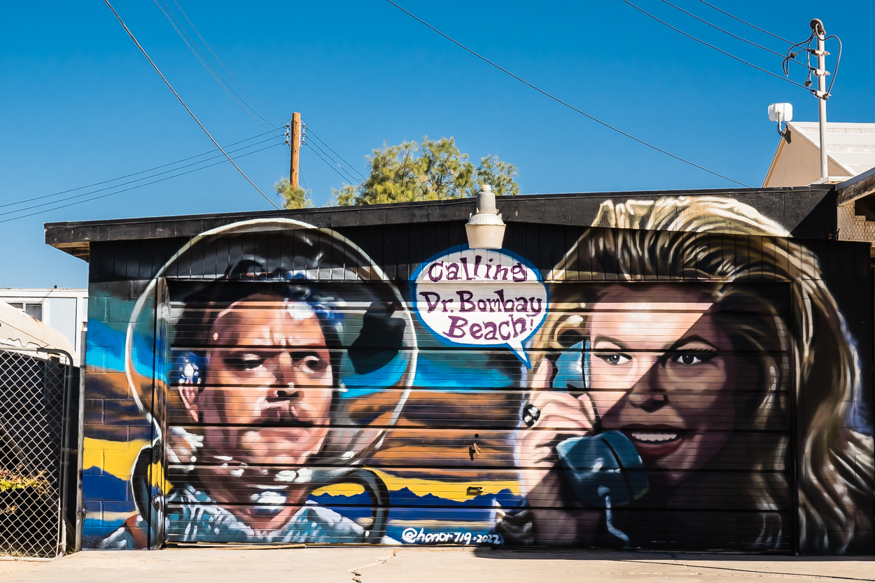 A painted garage door mural on a residence in Bombay Beach, California of a telephone call.