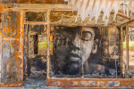 A building gutted by wildfire has a large face painted on an inside wall, looking out to the street, in the town of Paradise, California the site of the Camp Fire in 2018.