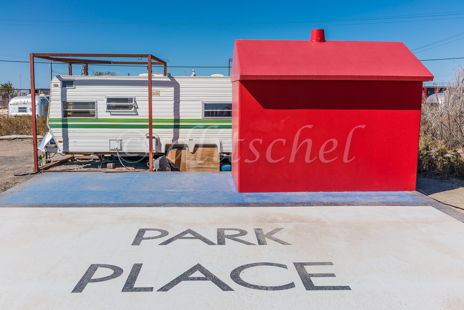A life-sized Monopoly hotel on a concrete pad with {quote}Park Place{quote} painted on the pad in Bombay Beach, California.
