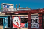 Two buildings in Bombay Beach, California painted with miscellaneous religious, anti-racisim, and other categories of statements by the artists.