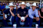 Young cowboys sit in a crowd in the grandstands watching a rodeo in the Central Valley of California. To purchase this image, please go to my stock agency.