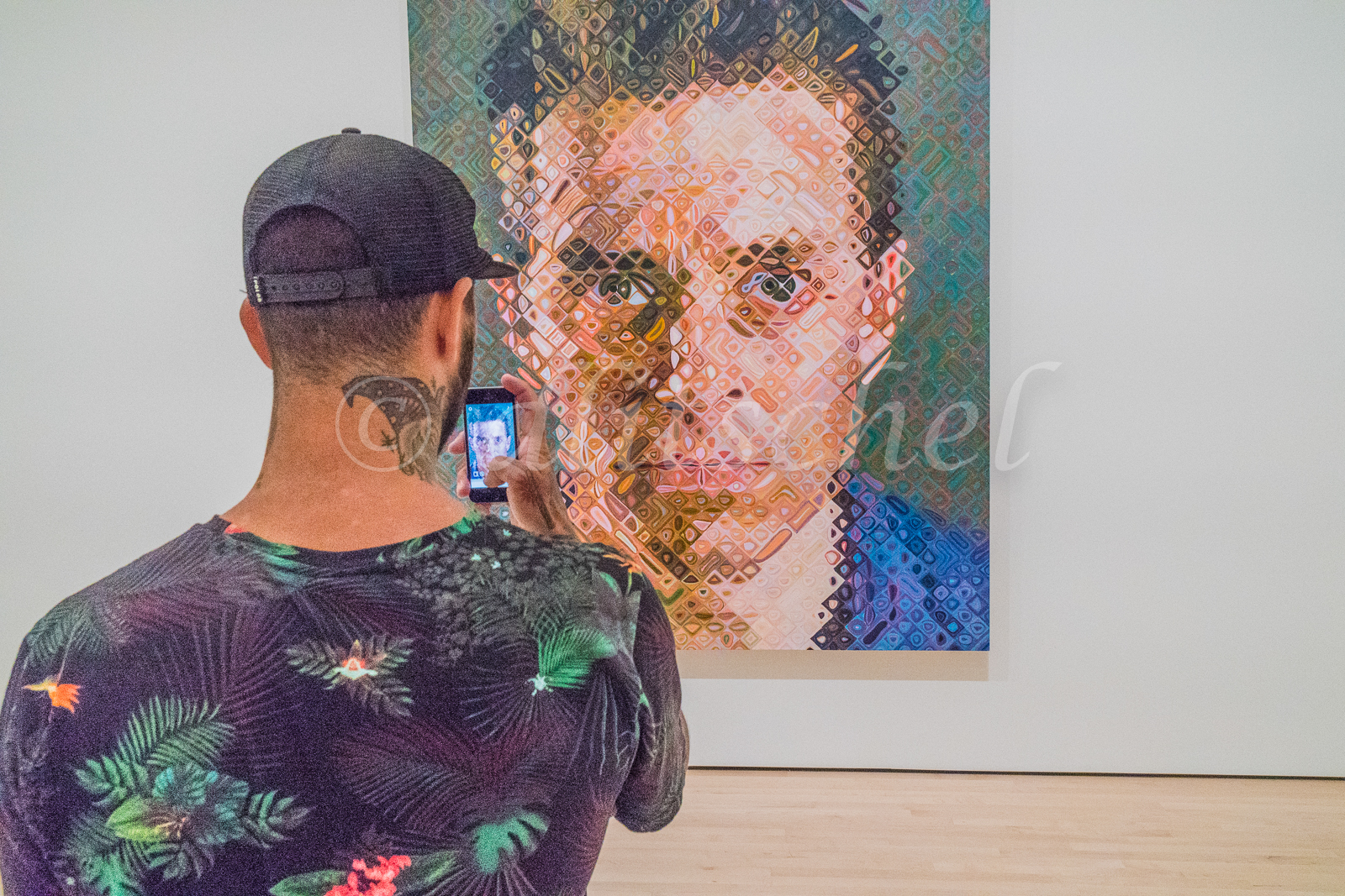 Man looking at Chuck Close Painting