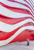 A person is dwarfed by the exterior of the contemporary architecture of the Petersen Automotive Museum in Los Angeles.