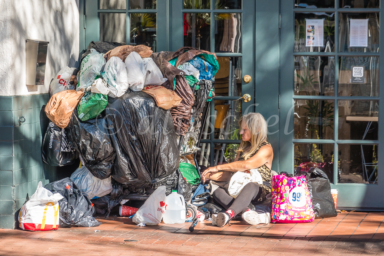 Homeless woman camped out at a vacant storefront on State Street in Santa Barbara, California.