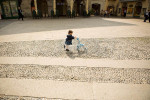 An Italian toddler pushes a baby stroller in the Lake Como city of Como Italy. To purchase this image, please go to my stock agency click here.
