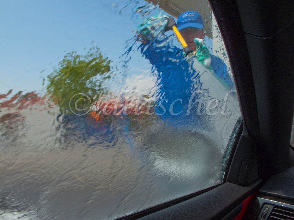 The car wash attendant hoses off the soap with a high pressure nozzle at a car wash on upper State Street in Santa Barbara, California. This car wash, like most others today, must recycle the water it uses due to drought conditions in California over recent years and issues with water shortages in general in the Western United States.
