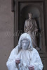A street performer dressed in all white and white face mimics the dress of the statue from Renaissance times in front of the Uffitzi Gallery in Florence, Italy.