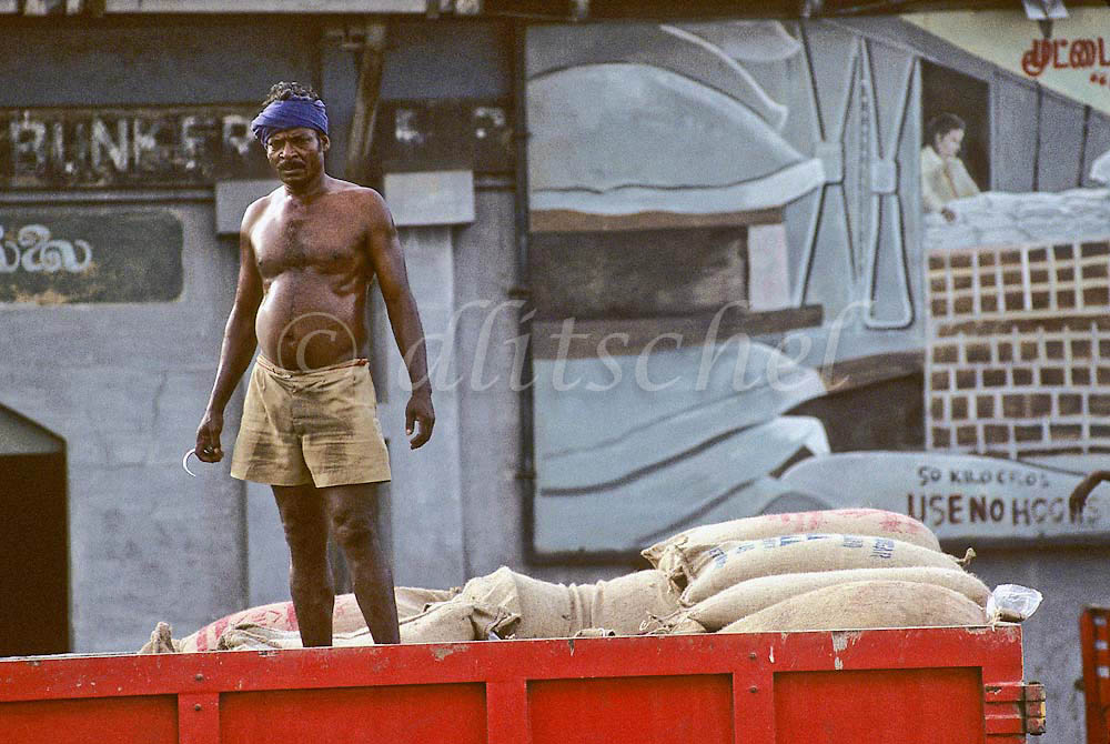 A dockworker with a large hook unloads cargo in the southern Indian city of  Chennai in the state of Tamil Nadu.To purchase this image, please go to my stock agency click here.