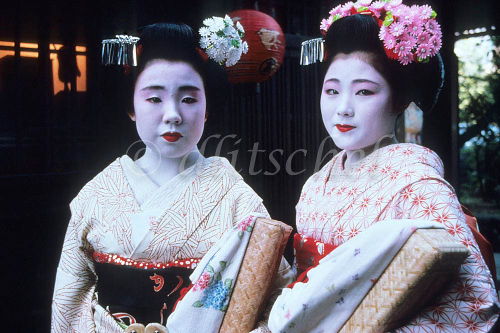 Two Maiko photographed as they walk at dusk in the former Imperial city of Kyoto in the central part of the island of Honshū, Japan. To purchase this image, please go to my stock agency.

