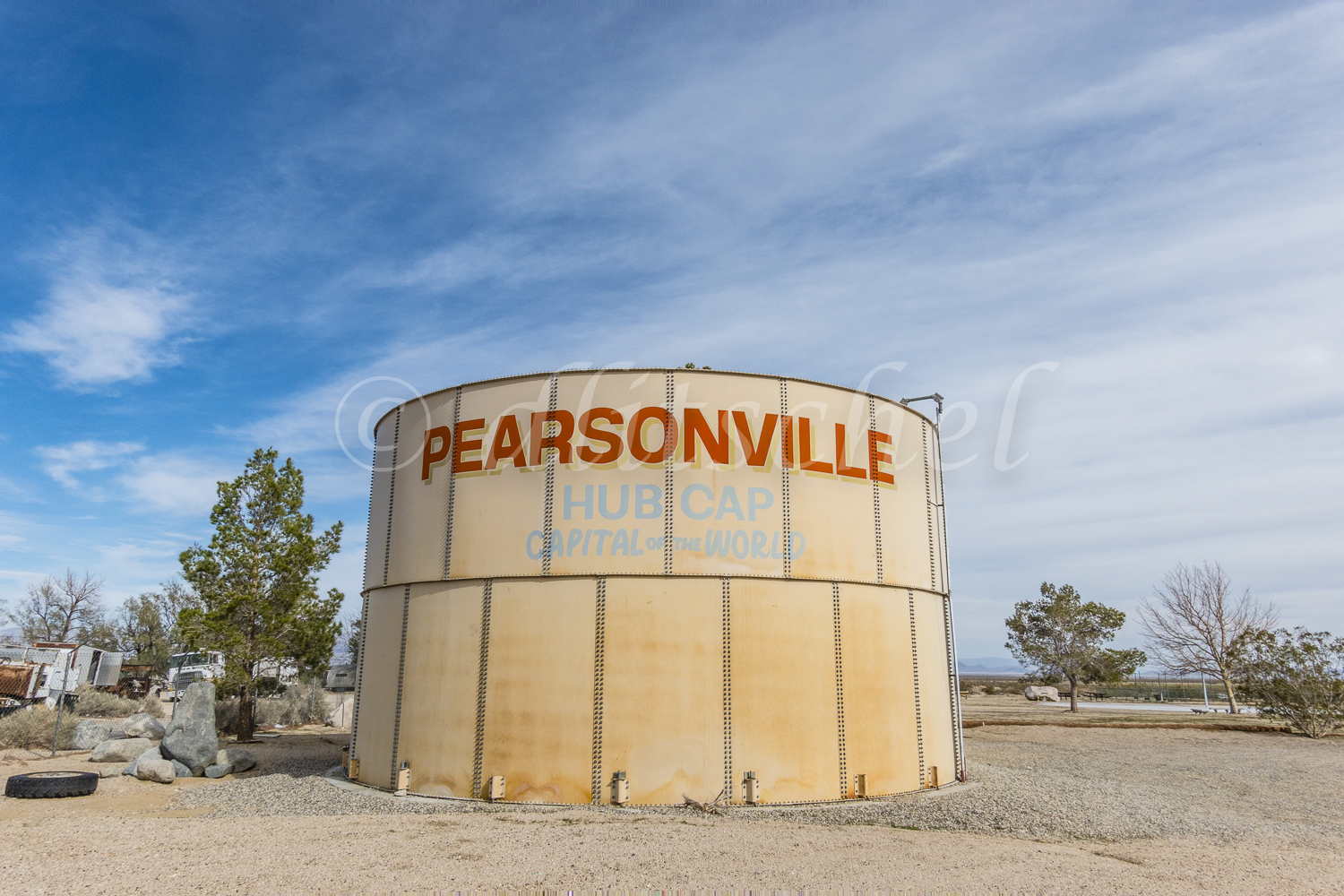 A large water tank at the semi ghost town of Pearsonville, California that has painted on it {quote}Hub Cap Capital of the World{quote} due to the collection of 80,000 hubcaps by Lucy Pearson.