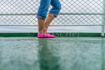 A girl in jeans and hot pink shoes stands by the ship's railing while traveling on the ferry between Prince Edward Island and Nova Scotia, Canada.