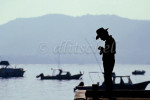 Silhouette of a man fishing at harbor of Zihuantanejo, Mexico. To purchase this image, please go to my stock agency click here.