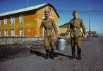 Two Russian soldiers stationed in the far north Arctic town of Dikson, located at the far northern extremes of the Krasnoyarsk Krai, on the Kara Sea, carry a metal container of milk outside their barracks. To purchase this image, please go to my stock agency click here.