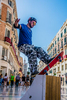 Skateboarding street performer, permanently afixed to his stand as a way to get money from passerbys in Málaga, Spain.