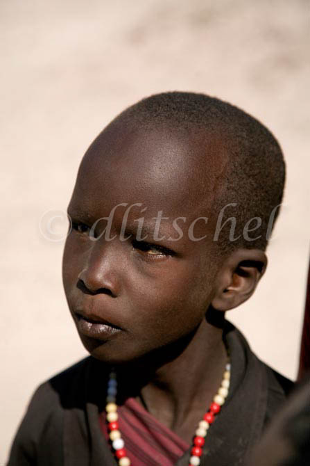 A head and shoulders image of a young Masai boy in the bush of the Sinya area of northern Tanzania near the border with Kenya. To purchase this image, please go to my stock agency click here.