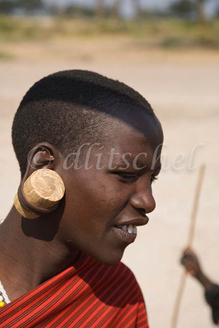 A young Masai warrior wears the traditional large wooden plugs in his earlobs in the Sinya area of northern Tanzania in east Africa. To purchase this image, please go to my stock agency click here.