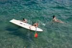 An Italian family swims with surf sail board in the waters of Lake Como at Tremezzo Italy. To purchase this image, please go to my stock agency click here.