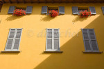 Detail of the side of a building with typical shutters and flower boxes in Varenna, Italy. To purchase this image, please go to my stock agency click here.
