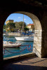The harbor of Varenna Italy is viewed through an archway in the waterfront walkway. To purchase this image, please go to my stock agency click here.